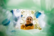 A person picks up recycled bottles.