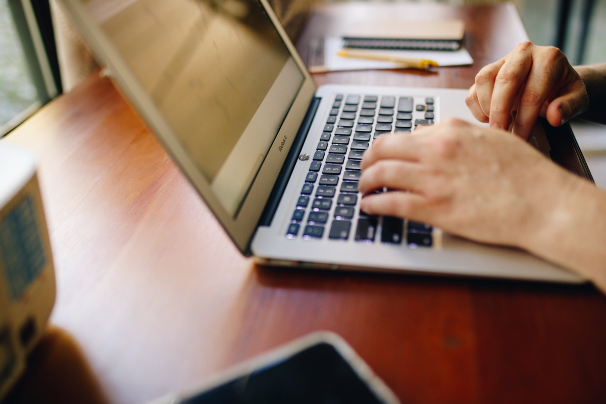 A woman types on her laptop. 