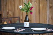 In this photo, a wine bottle is repurposed to be a vase.