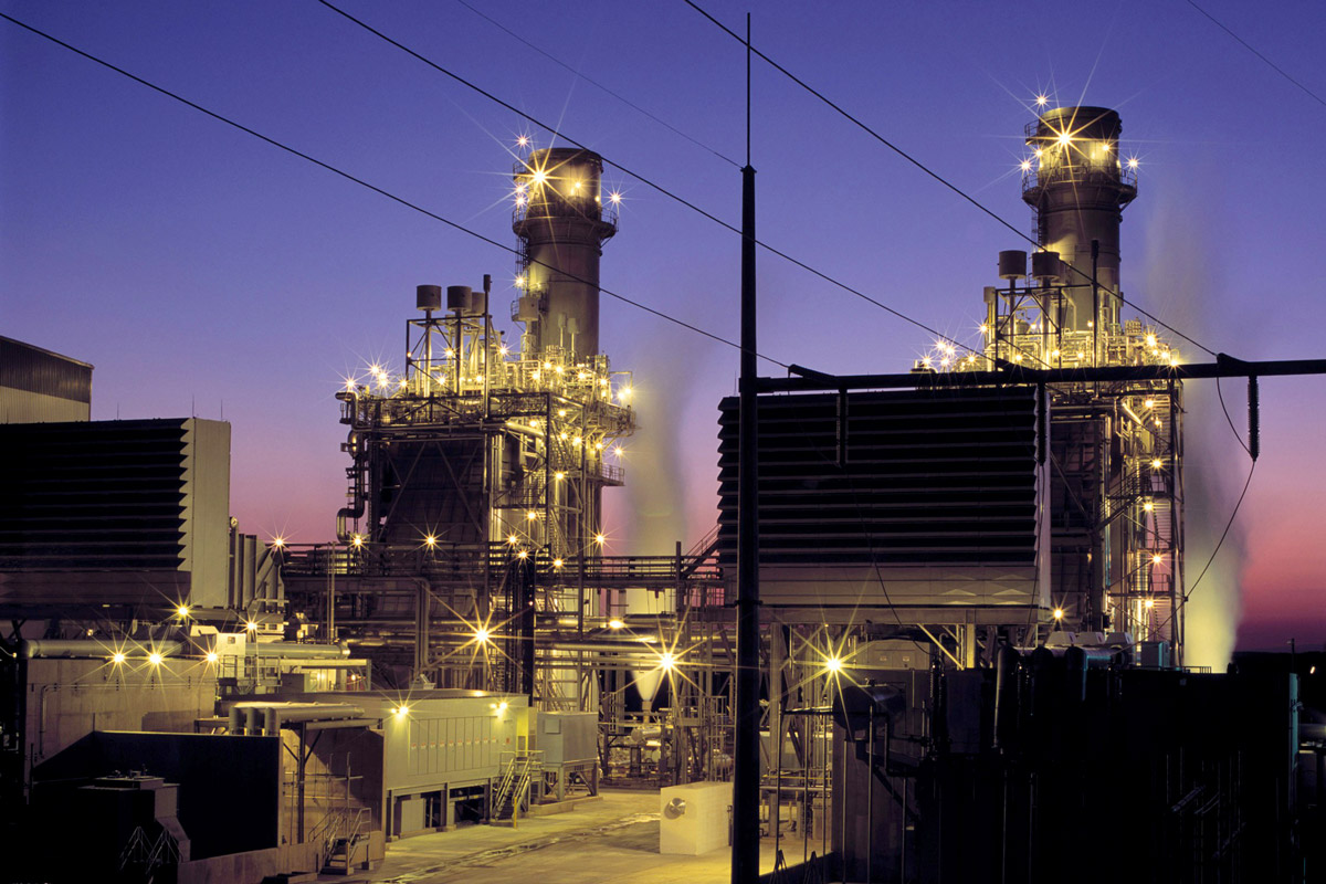 A natural gas facility is photographed at dusk.