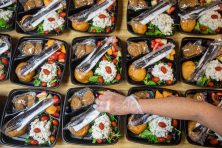 A woman makes prepared lunches for customers.