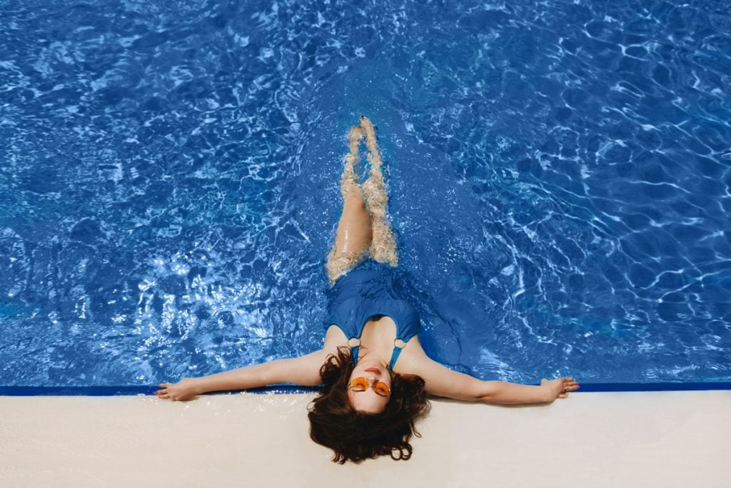 A woman lays in a pool.
