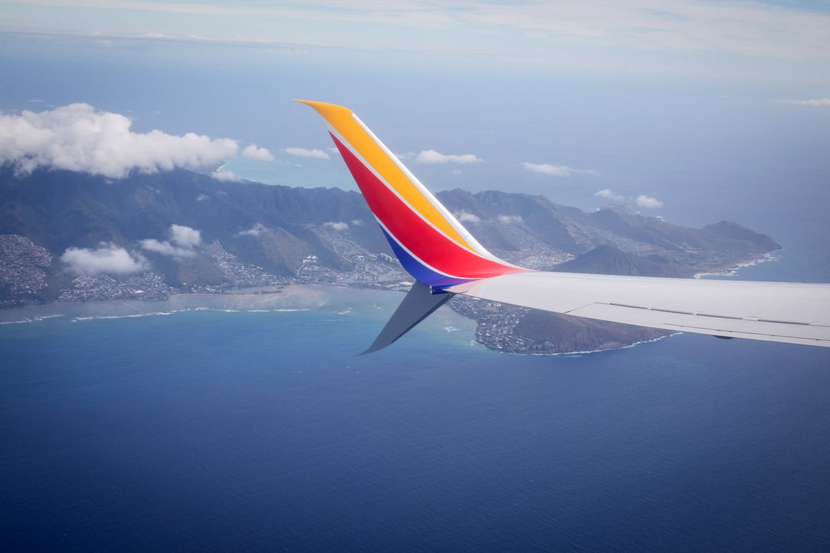 The tail end of a southwest airline flight is seen flying over the water in Hawaii.