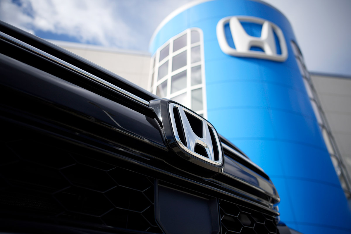 The Honda company logo shines off the snout of an unsold vehicle outside a Honda dealership.