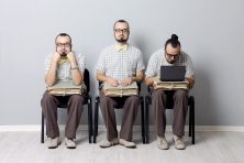 A stock photo shows a man waiting to be interviewed three different ways. In the photo, he looks bored, interested, and busy working. he