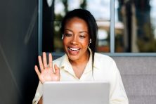 A woman waves as she has a video chat with someone.