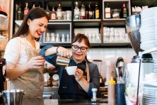 A woman with Down syndrome makes coffee at a coffee shop.