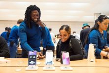 People smile as they look at the new iPhone at an apple store in NYC.