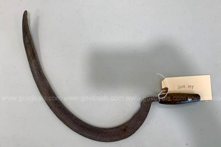 A sickle sits on a table.