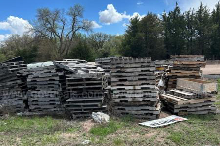 Wooden pallets sit in a field. 