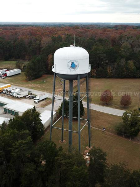 A water tower stands in a rural town.
