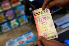 A man displays his Powerball lottery numbers after buying a ticket at a convenience store.