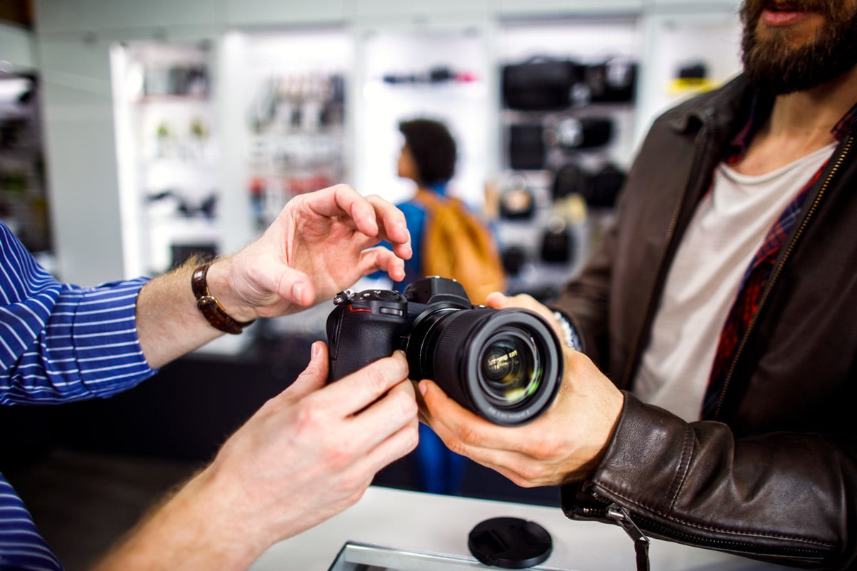 A person looks at a DSLR camera at a store.