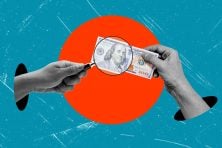 A microscope is shown above money with two hands reaching for it.