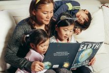 A family reads a book about Earth together.