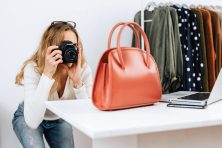 A woman photographs a purse to sell online.