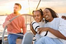 A family spend time on a sail boat at sunset.