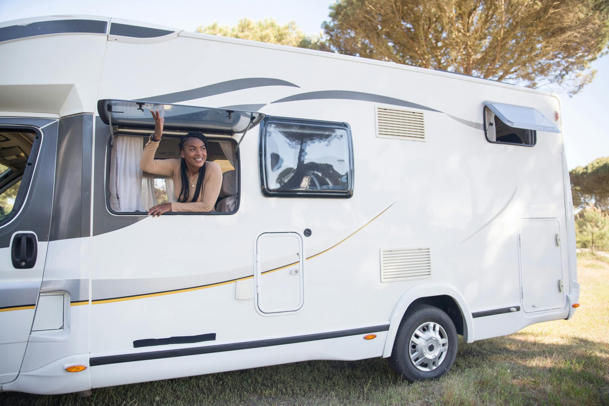A woman sticks her head out of the window of an RV.