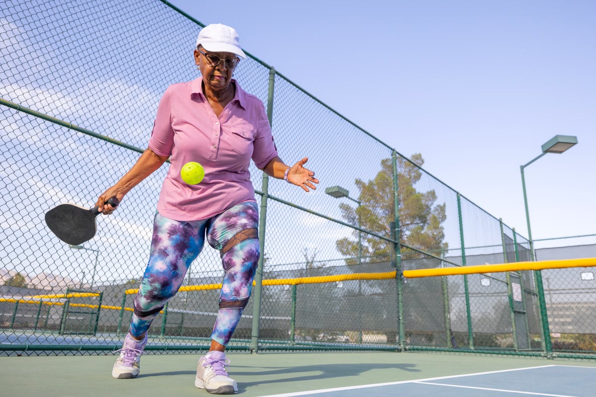 A woman plays pickle ball. 