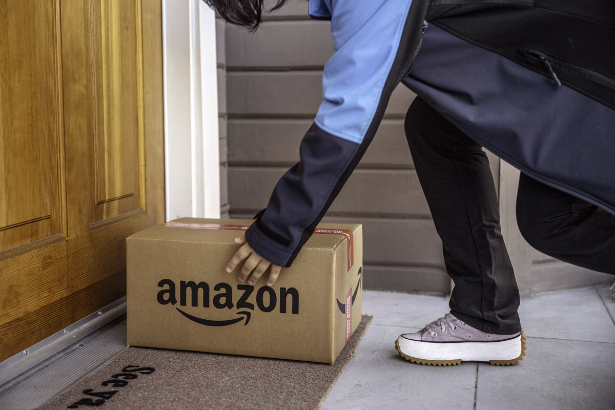 A person drops off an amazon package at a person's house.