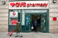 People walk out of CVS Pharmacy retailer drug store in the Harlem neighborhood of New York City.