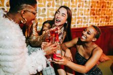 A group of women celebrate New Year&rsquo;s Eve with champagne.