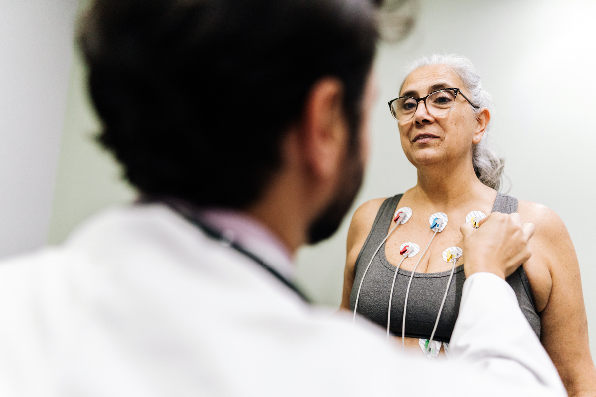 A woman gets hooked up to a machine while attending a doctor's visit.