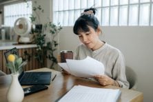 A woman looks over documents.