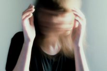 A woman moves her head back and forth in motion meant to represent depression.