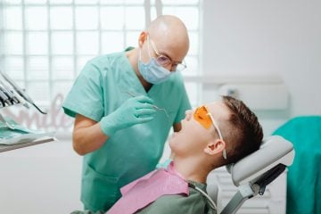 Someone gets their teeth looked at by a dental hygienist, which is one of the best trade jobs for 2025.