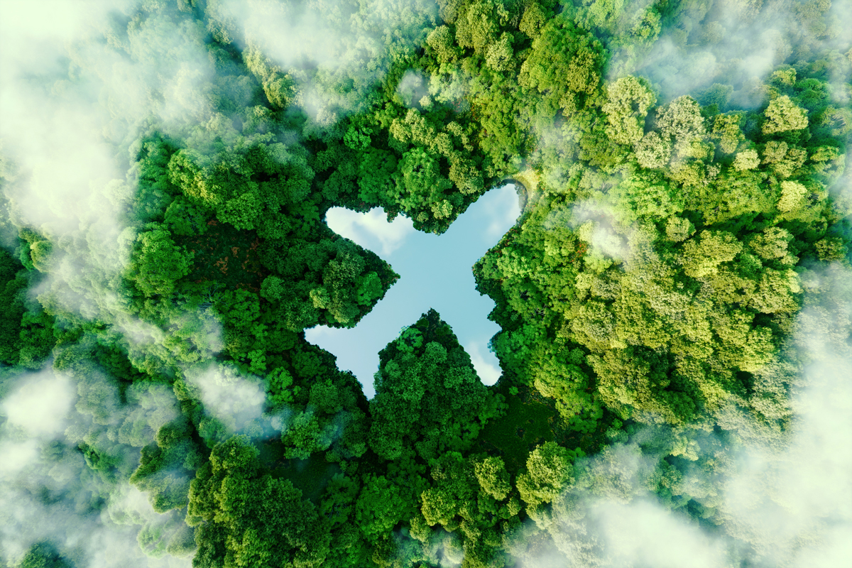 An airplane shaped in water flies over trees and clouds.