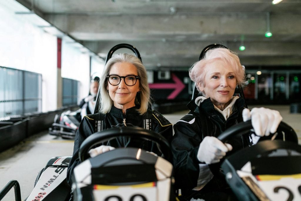 Two women sit in a go cart.