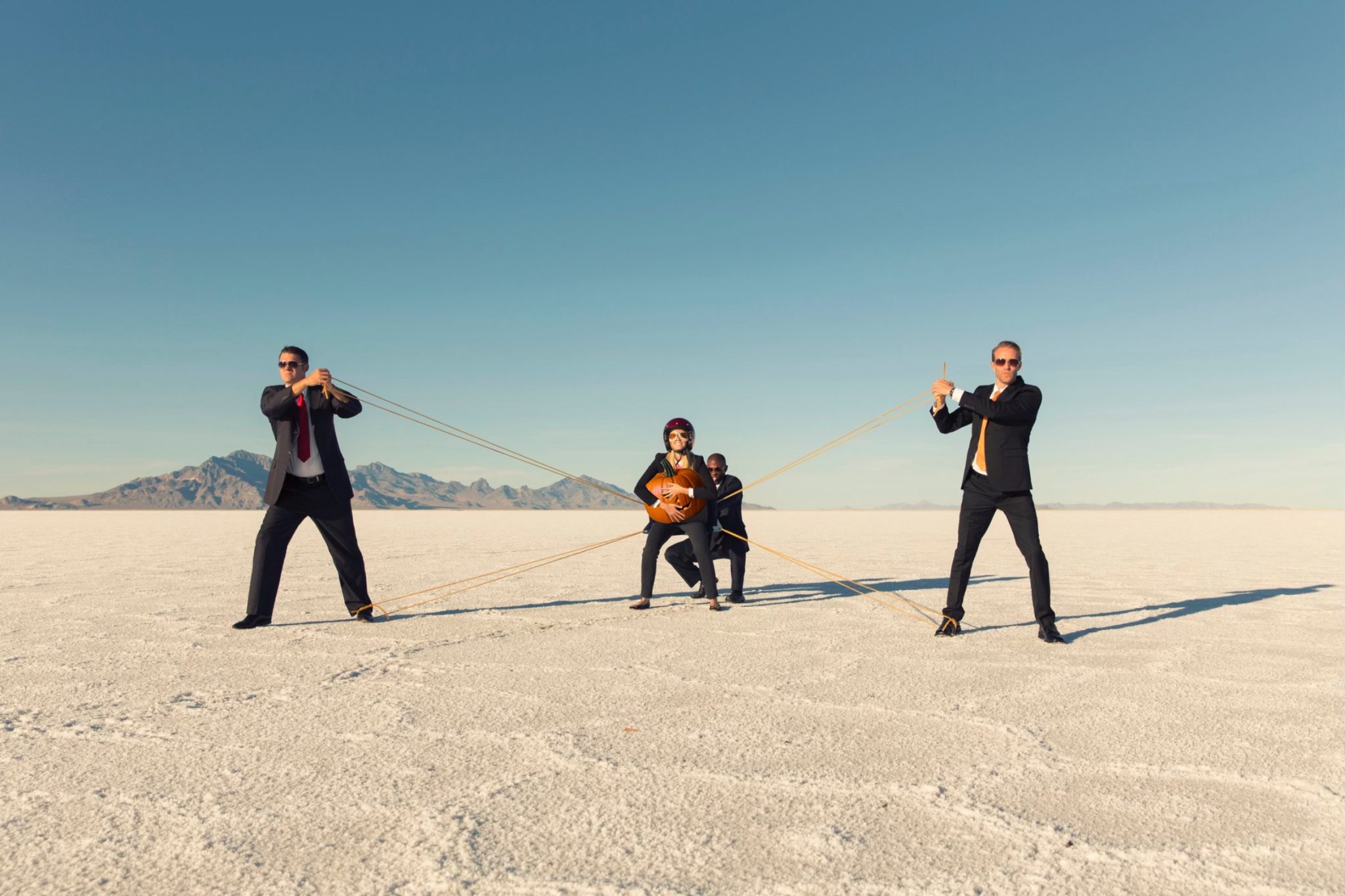 businessmen launching business woman holding pumpkin.