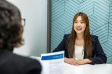 A job applicant attends an interview as her resume is reviewed by a prospective employer.