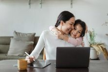 A young mother takes a break from freelance work on her laptop computer to enjoy her daughter&rsquo;s company.