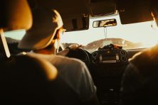 A man looks out into the road while driving a car.