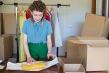 A young lady packages up clothing items to be shipped.