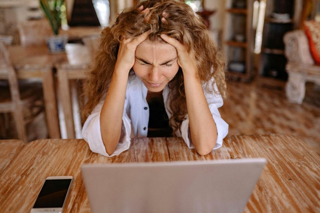 A woman looks stressed out as she looks at her computer.