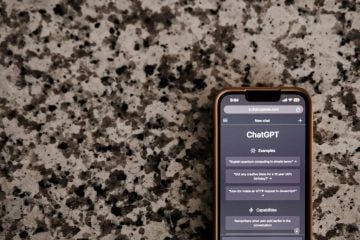 A phone shows ChatGPT questions on its screen.