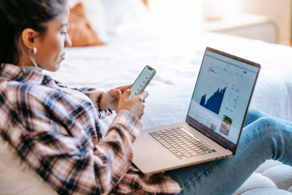 A woman checks her investment portfolio on her laptop. 
