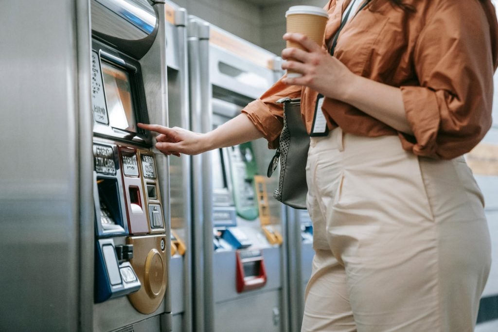 A woman uses an ATM machine.
