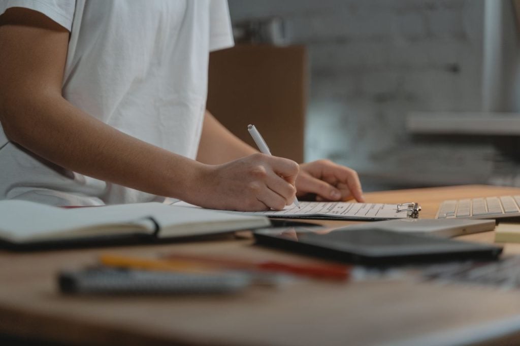 Person checking off completed budget goals and staying on track financially
