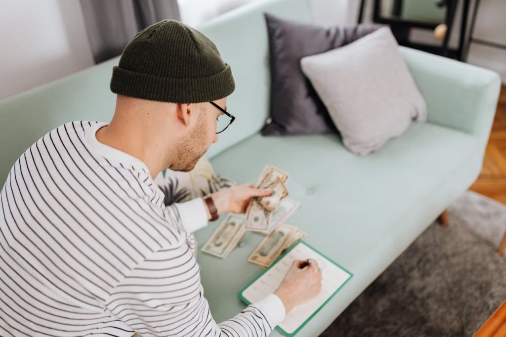 Person applying the 60/20/20 budget rule to plan their monthly spending