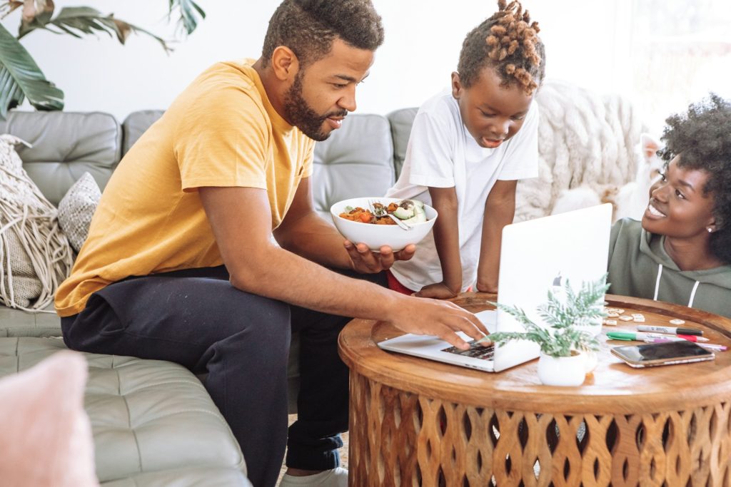 Parent reviewing the family household budget while managing childcare at home